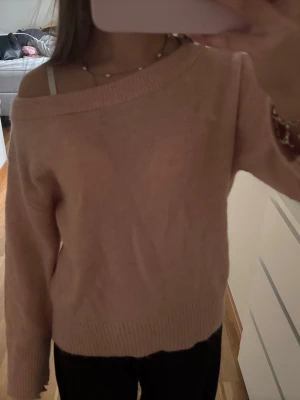 Ljusrosa off shoulder stickad tröja - Mysig ljusrosa stickad tröja från Gina Tricot med bred ribbad kant och off shoulder-design. Tröjan har långa ärmar och en avslappnad passform, perfekt för en chill och trendig look. Materialet känns mjukt och fluffigt. Aldrig använd bara provad, den är inte nopprig och har inga defekter💕💕