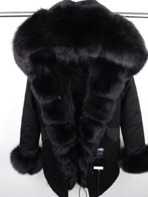 Svart pälsjacka med stor luva - Säljer en svart pälsjacka med superstor fluffig luva och breda pälskanter längs öppningen och ärmsluten. Jackan har rak passform, dragsko i nederkant och två fickor framtill. Materialet är en mix av tyg och mjuk fuskpäls som ger en lyxig och varm känsla.