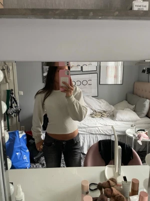 Vit stickad tröja med puffärm - Trendig vit stickad tröja med puffärmar och rund hals. Tröjan har ribbade muddar vid ärmslut och är tillverkad i ett mjukt, strukturerat material. Passformen är något croppad och ger en modern siluett.