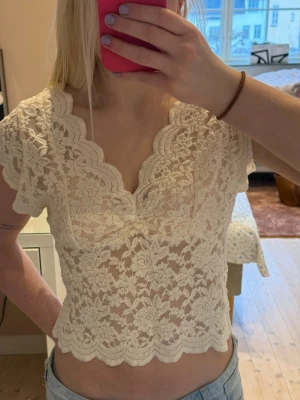 Populär spetsblus från Zara  - Säljer denna superfina och populära spetsblusen från Zara med korta ärmar och v-ringad hals. Perfekt nu till sommaren, funkar till fest men även att ha i vardagen. Knappt använd, storlek L men skulle säga att den passar S-L❣️