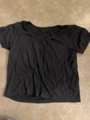 Svart kortärmad t-shirt - En enkel svart t-shirt med korta ärmar och rund halsringning. Passar perfekt till jeans eller kjol för en avslappnad look. Tillverkad i mjukt tyg som känns skönt mot huden.