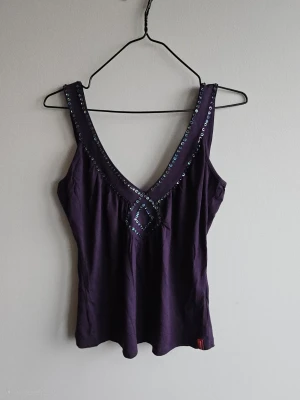 Lila linnetopp med paljettdetaljer - Supersnygg lila linnetopp med djup v-ringning och glittriga paljetter längs ringningen och framtill. 