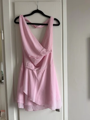 Ljusrosa klänning med pärldetalj - Säljer en ljusrosa kortklänning med pärldetalj! Den är aldrig använd! 