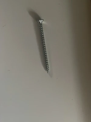 Metallskruv med försänkt huvud - En silverfärgad metallskruv med försänkt huvud och gängad kropp. Perfekt för olika bygg- eller hobbyprojekt där du behöver en stabil och pålitlig skruv. Passar till trä eller metall beroende på behov.