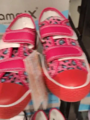 Rosa tofflor med enhörningsmönster - Säljer ett par söta rosa tofflor med gulligt enhörningsmönster, regnbågar och moln. Tofflorna har en mjuk textilovandel och vit kant runt sulan. Perfekta för dig som gillar färgglada och lekfulla detaljer!