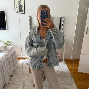 Oversized ljusblå jeansjacka - Säljer en oversized ljusblå jeansjacka med klassisk krage, bröstfickor med knappar och raka sömmar. Jackan har långa ärmar och en avslappnad passform. 