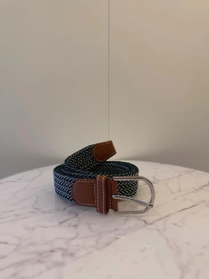 Grön vitt flätat bälte - Tja säljer helt nytt klassiskt svenskt flätat bälte från Bältgallerian i storlek 105cm i längd och 3,5cm i bredd. Dem är i ett elastiskt material och finns i flera olika färger i min profil.