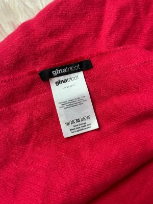 Rosa halsduk från Gina Tricot - Snygg rosa halsduk från Gina Tricot i 100% akryl. Halsduken har en klassisk rektangulär form med fransar i ändarna. Perfekt att svepa runt halsen för extra värme och stil under kyliga dagar.