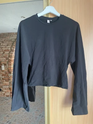 Svart långärmad topp med vida ärmar - Stilren långärmad tröja från Nelly med vida ärmar. Perfekt till kontoret eller en middag 🥰🌸