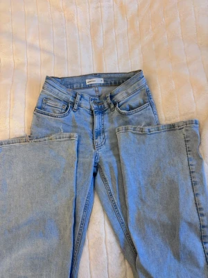 Ljusblå utsvängda jeans från Gina Tricot - Ljusblåa jeans från Gina Tricot i strl 32. Var skick, ljusare färg i verkligheten än på bild.