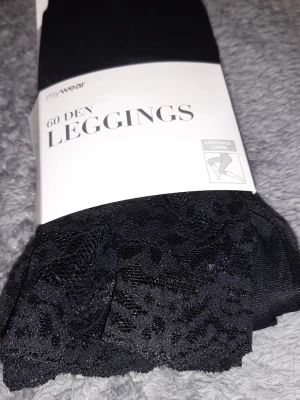 Svarta leggings med spetsdetaljer - Snygga svarta leggings från mywear i 60 den med spetsdetaljer längst ner. Tillverkade i 92% polyamid och 8% elastan för en stretchig och bekväm passform. Capri-längd och täckande material. Perfekta för att lyfta din outfit med lite extra stil. BRAND NEW WITH PACKAGING 