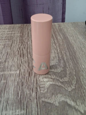 Läppstift från CAIA, Splendour Series - Läppstift från CAIA i nyansen Chic, en brun rosa ton. Förpackningen är cylinderformad och har en modern design med diskret logga. Perfekt för dig som gillar minimalistisk och trendig makeup.