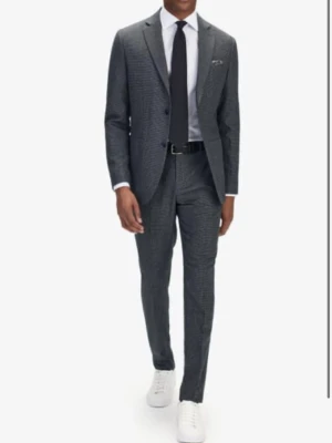 Ny kostym John Henric i ullblandning - Helt ny kostym från John Henric. Kostym funkar lika bra formella tillfällen som till vardags. Passformen är slim men inte skinny Färg: grå/svart Material: 70% ull o 30% polyester Nypris 3000 kr Storlek 44