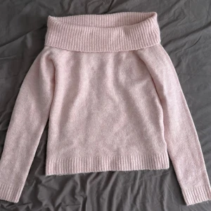 Ljusrosa off shoulder stickad tröja - Säljer en ljusrosa stickad tröja med bred ribbad off shoulder-krage och långa ärmar från Gina Tricot. Tröjan är ribbad vid ärmsluten och nederkanten. Den är i mycket bra skick då den använts en gång.