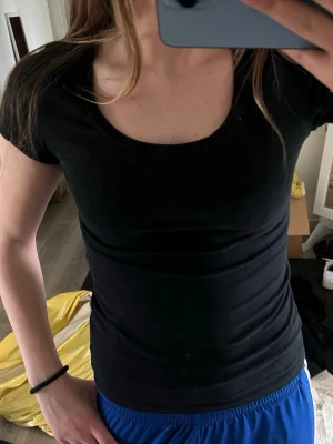 Svart basic t-shirt från 157 - En klassisk svart t-shirt från 157 med rund halsringning och korta ärmar. Modellen är slim fit och tillverkad i mjuk bomull som känns skön mot huden. Perfekt att matcha med jeans eller shorts för en enkel och clean look.