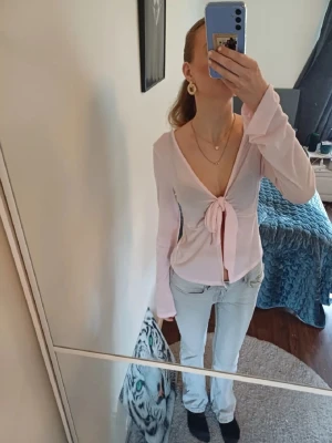 Ljusrosa omlottopp med knyt - Supersöt ljusrosa omlottopp med knyt framtill och djup v-ringning. Toppen har långa ärmar och är tillverkad i ett mjukt, stretchigt material som sitter snyggt och bekvämt. Materialet är tunt så man ser igenom lite som man ser på mina bilder. Skriv om ni har frågor. Priset går att diskutera ❤️ storlek M men passar mig som vanligt vis använder S men skulle endå säga lite mer M ❤️