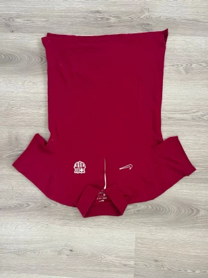 Vinröd Nike Dri-Fit pikétröja Barcelona - Snygg vinröd Barcelona pikétröja från Nike med Dri-Fit material som andas. Tröjan har klassisk krage, knappar framtill och ett broderat klubbmärke på bröstet. Perfekt för träning eller sportiga tillfällen. Mycket bra skick Storlek S