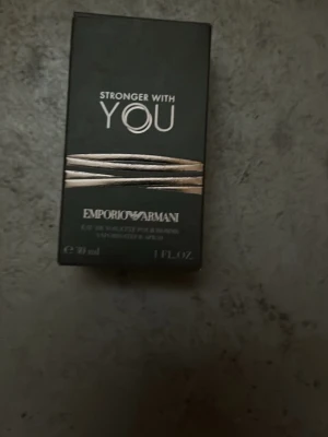 Emporio Armani Stronger With You parfym - Emporio Armani Stronger With You är en elegant parfym i en stilren glasflaska med rundad form och metallisk kork. Förpackningen är svart med guldiga detaljer och text. Flaskan rymmer 30 ml och har en modern, lyxig känsla. Och jag har inte använt den!