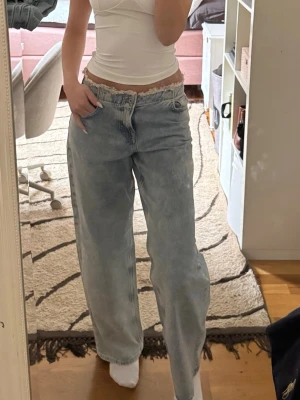 Ljusblå baggy jeans - Säljer ett par ljusblå baggy jeans med raka ben. Jeansen har klassisk femficksdesign och är tillverkade i denim. Perfekta för en avslappnad och trendig look.