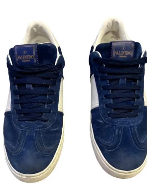 Blåa sneakers från Valentino Garavani - Snygga sneakers från Valentino Garavani i mörkblå mocka med vita detaljer och vita sulor. Klassisk låg modell med blå skosnören och logga på plösen. Perfekta för dig som vill ha en stilren och exklusiv look.