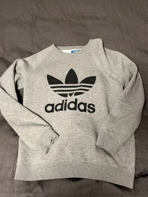 Adidas Tröja - Tja säljer nu en tröja från Adidas i storlek M och färgen grå. Fint skick på tröjan. Hör av dig vid frågor eller funderingar.