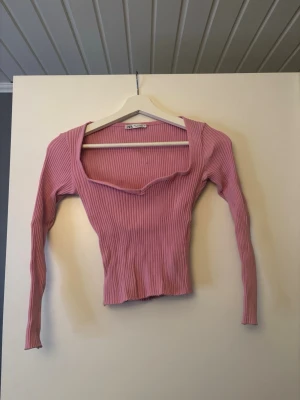 Rosa ribbad topp från Zara - Rosa  ribbad topp från Zara med lång ärm och snygg v-ringad halsringning. 
