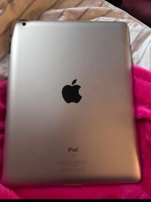 Apple iPad silver 16GB - Säljer en silverfärgad Apple iPad med 16GB lagring Snapchat, TikTok, YouTube och sånna appar funkade inte för mig men den e jätte bra för dig som gillar o spela spel och YouTube funkar om man söker på de genom Google ❤️. Surfplattan har en stilren design i aluminium med Apple-loggan på baksidan. Perfekt för surf, appar och media. Laddas via lightning-kontakt och har kamera på baksidan.