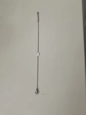 Tunt silverfärgat armband med fjäril - Ett stilrent och tunt armband i silverfärg med en liten fjärilsberlock i mitten. Kedjan är enkel och smal med ett klassiskt lås. 