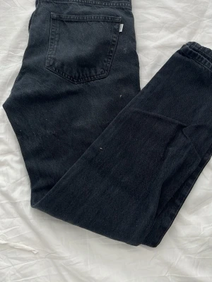 Svarta jeans från Woodbird - Säljer ett par svarta jeans från Woodbird med klassisk femficksdesign och raka ben. Jeansen är tillverkade i denim och har en snygg, enkel look som passar perfekt till sneakers eller boots. Storleken 30/32, hör av dig vid frågor o priset går självklart att diskutera😄