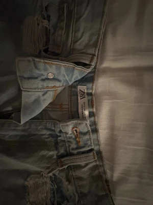 jeansshorts från zara  - Säljer ett par ljusblå jeansshorts från Zara med slitningar och trasiga detaljer framtill. Bara användt fåtal gånger, hör av er vid frågor!! 💗 