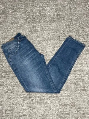 Dondup George jeans - Hej jag säljer ett par Dondup George. Jeansen i riktigt snygg blå färg perfekt för dig som vill ha ett par kvalitetsjeans med grym passform. Nypris ≈3500kr, mitt pris 599kr.  Skick: 9/10 Storlek: W32 Midja: 39cm Lår: 25cm Ytterlängd: 100cm Innerlängd: 80cm  Skriv gärna om du vill ha fler bilder eller har frågor!
