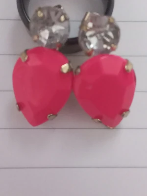 Rosa örhängen  - Örhängen med stora, droppformade stenar i neonrosa och runda, klara stenar upptill. Fästen i guldfärgad metall. Inte särskilt använda men de har en del år på nacken.