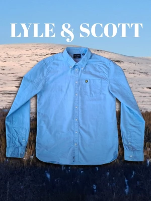 Lyle & Scott skjorta - Säljer en ljusblå Lyle & Scott tröja. Tröjan är 100% bomull och den ljusblåa färgen gör att den är perfekt nu när sommaren närmar sig! Tröjan har den gula Lyle & Scott fågeln på vänstra bröstet och är I storlek 15-16 år som motsvara ca xs/s. Modellen I bild är 173cm lång Skjortan har inga synliga defekter. Hör gärna av er om ni har några funderingar!😁 Pris kan diskuteras vid snabb affär👍