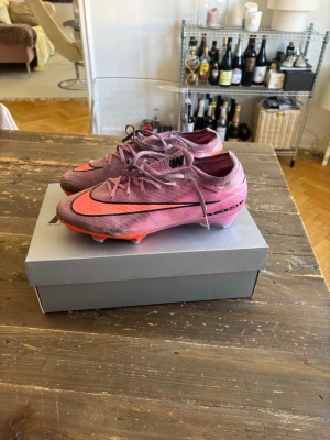 Nike Mercurial rosa fotbollsskor - Säljer ett par Nike Mercurial fotbollsskor i rosa och neonorange med svarta detaljer. Skorna har snörning, låg profil och är tillverkade i ett lätt syntetmaterial för bästa bollkontroll och grepp på planen. Perfekta för dig som vill sticka ut på fotbollsplanen. Tillkommer låda och skopåse. Fint skick 7/10. Kom gärna med frågor😃