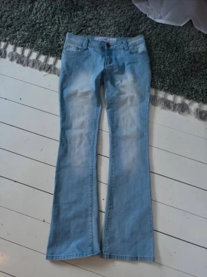 Ljusblå bootcut jeans - Säljer dessa sååå så snygga Lågmidjade jeansen som är flared/bootcut. Passar inte mig så säljer därav! Midjemått:38cm, innerbenslängd: 82cm