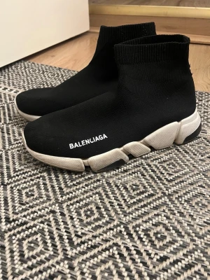  Speed Trainer svarta sneakers -  Speed Trainer sneakers med vit tjock sula och stickad strumpliknande ovandel. Loggan står tryckt i vitt på sidan. Skorna har en modern, minimalistisk design och är tillverkade i textil och gummi.