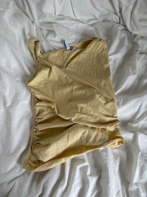 Gul osymmetrisk topp - En unik gul osymmetrisk topp från &other stories. Är så fin på och har detaljer som gör den basic men samtidigt inte. Så fin till sommaren 