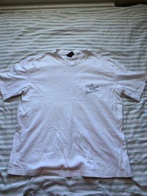 Vit t-shirt med palmtryck och text - Vit t-shirt med tryck på bröstet och stort palmtryck på ryggen. Texten på ryggen ger semesterkänsla med 'Puerto Vallarta Bar' och adress i Mexiko. Klassisk passform och rund hals. Perfekt för dig som gillar chill vibes och snygga prints. Från H&M Storlek:Loose fit M Skick:Använd men väldigt bra skick o tvättad! Diskuterar även gärna pris🥳 