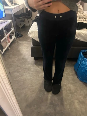 Juicy couture  Mörkblå mjukisbyxor  - Säljer ett par mörkblå mjukisbyxor med raka ben och hög midja. Byxorna har dragsko i midjan och två bakfickor med vita knappar. Sköna och perfekta för chill dagar. Materialet känns mjukt och stretchigt.