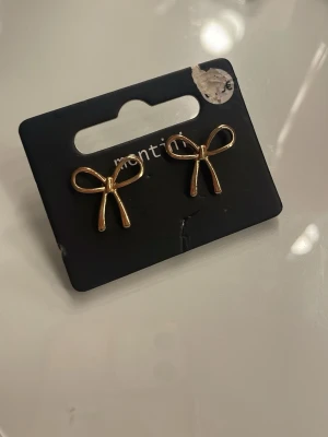 Örhängen  - Guldiga rosett örhängen som är oanvända💕 Förpackning är lite skadad men det är inget fel på örhängena 💕 Märket är Montini