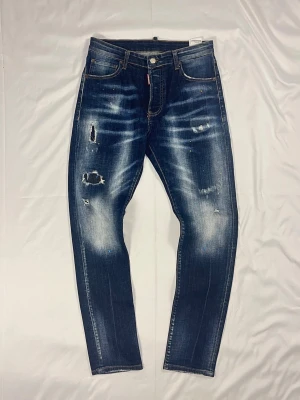 DSQUARED2 Slim Jean 93472 – Blå Distressed Wash – W44 – Nyskick - DSQUARED2 Slim JeanFärg: Blå distressed wash | Modell: Slim Jean 93472 | Storlek: W44 | Skick: 10/10 | Stretch | Distressed & färgstänk | Hör av dig vid frågor!
