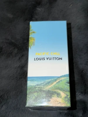 Louis Vuitton Pacific Chill parfym 100ml - Exklusiv parfym från Louis Vuitton, Pacific Chill. Förpackningen är ljusblå med ett tropiskt landskap och palmer, samt LV-logga på toppen. Lyxig och stilren design som sticker ut i parfymhyllan.