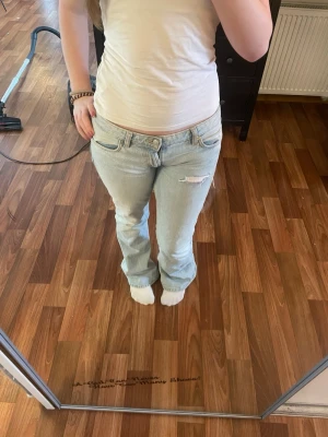 Ljusblå bootcut jeans med slitning - Säljer dessa då jag knappt använder dem o behöver få bort. Dem är nersydda till lowwaist och har gjort hålet själv. Är lite långa för mig som är 167 och ganskat långa ben🙈 priset kan diskuteras