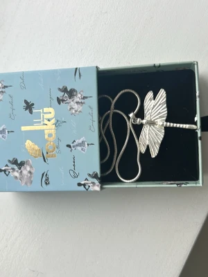 Ioaku trollslända halsband  - Snyggt silverfärgat halsband från ioaku med ett detaljerat trollslände-hänge. Nästan oanvänd, mycket bra skick och kommer med lådan. Jag rekommenderar!💕