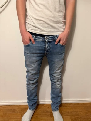 Ljusblå slim fit jeans från jack&jones  - Säljer ett par ljusblå slim fit jeans med slitningar och tvättade detaljer. Jeansen är i storlek w29 l30 och har klassisk femficksmodell, normal midja och dragkedjegylf. Perfekta för en avslappnad och trendig look. Pris kan diskuteras✅