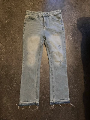 Ljusblå flared jeans - Säljer ett par ljusblå jeans som är flared  slitna detaljer på benen. Jeansen är helt nya och passar med mycket kan gå ner vid snabbt köp stlrk 32:30