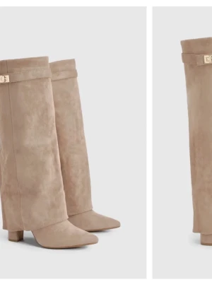 Beige mockastövlar med bred skaft - Snygga beige stövlar i mjuk mocka med breda, raka skaft och spetsig tå. Stövlarna har en låg klack och en diskret guldfärgad detalj upptill. Perfekta för att lyfta din outfit med en trendig touch.