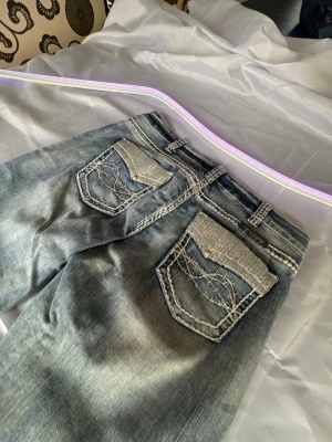 Gråa jeans med bling från Cowgirl tuff Y2k - Snygga gråa jeans från Cream Team med raka ben och slitna detaljer. Bakfickorna har bling och dekorativa sömmar som ger extra attityd. Perfekta för dig som vill sticka ut lite extra. Klassisk femficksmodell och bekvämt denimtyg.