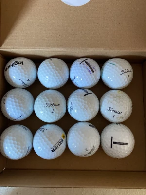 Golfbollar Titleist och Logitech - Säljer ett set med 12 vita golfbollar från Titleist i c/d klass. Några bollar har logotyper som Beijer och Skånes Golfklubb. Klassisk rund form med dimple-mönster, tillverkade i slitstarkt material. Perfekt för golfentusiasten som vill fylla på förrådet.