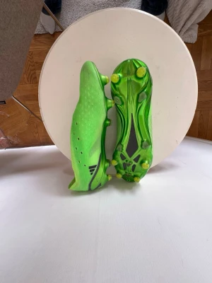 Adidas X Speedportal.1 FG - Säljer ett par Adidas X speedportal.1 FG i en ljus grön färg med svarta detaljer. Skorna har låg profil, ingen snörning och mönstrad ovandel i syntetmaterial för bra grepp och kontroll på planen. Perfekta för dig som vill sticka ut på fotbollsplanen.